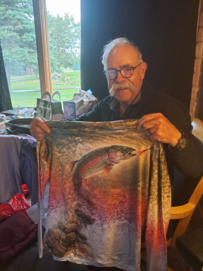 Customer holding up a trout shirt received as a birthday gift
